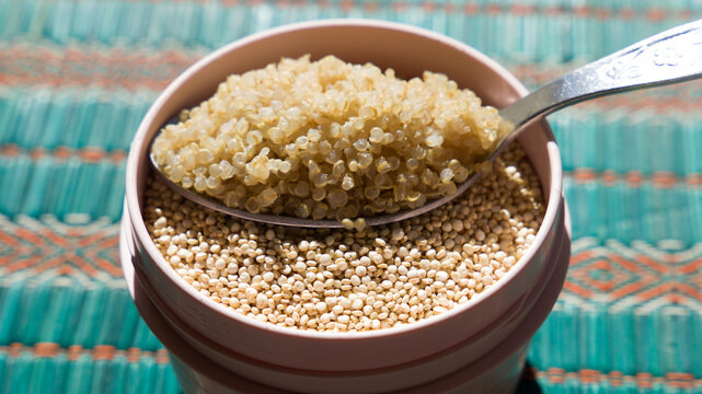 a tablespoon of quinoa on a bowl of raw quinoa