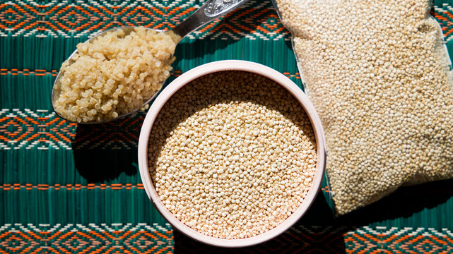 bag and container with raw quinoa and a tablespoon of cooked quinoa