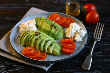 Plate with avocado, cherry tomatoes and cream cheese. Healthy breakfast or snack. Keto diet.