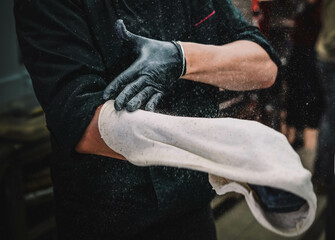 
Preparaci&oacute;n de una pizza casera de estilo italiano por un especialista.(masculino)
