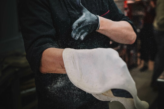 
Preparaci&oacute;n de una pizza casera de estilo italiano por un especialista.(masculino)
