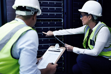 The more you know the more you grow. Shot of two technicians working together in a server room.