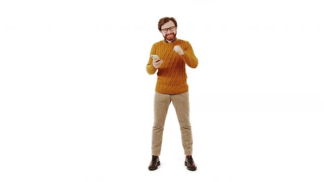 middle-aged brunet bearded man looking at his phone and happily gesturing white background isolated studio shot. High quality 4k footage