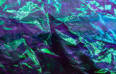 colorful grunge background. Rough texture. Neon light red green blue shiny wrinkled rock dark abstract art.