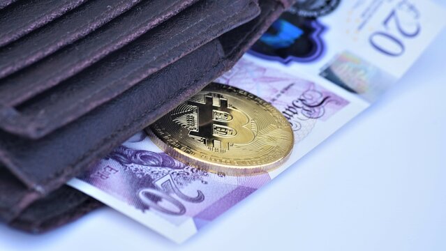 Bitcoin with twenty poud note and wallet.