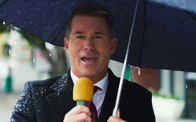 Its a very gloomy day in the city today. Portrait of a mature male reporter holding a microphone...