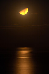 Half moon and its reflection in the sea