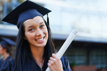 Upwards and onwards. A young college graduate smiling at the camera.