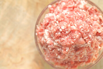 minced pork. fresh raw minced meat close-up in a transparent cup on a wooden table. Meat products.