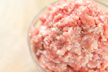 minced pork. fresh raw minced meat close-up in a transparent cup on a wooden table. Meat products.Ground fresh meat close-up.