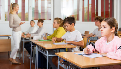 Fototapeta na wymiar Teenage students are sitting at their desks in classroom