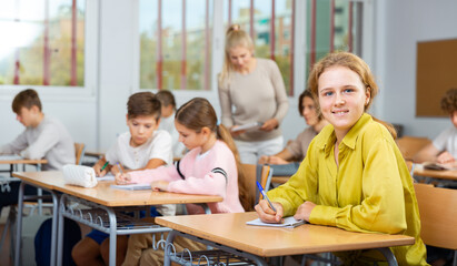 Fototapeta premium Teenage students are sitting at their desks in classroom