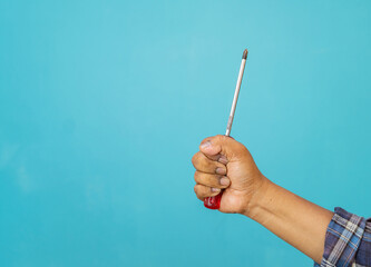 The carpenter hand holding a red plastic handle screwdriver