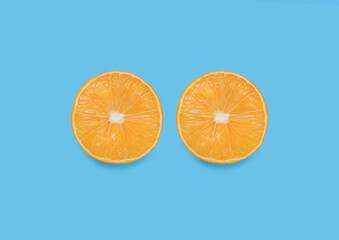 Tropical fruit. Top view photo in close up. Halved ripe orange on light blue backdrop