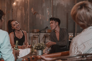 Group of young friends enjoying meal and celebrating friendship in pub and restaurant