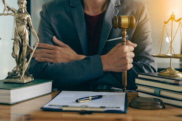 Attorney in the office with Gail Brass. statue of justice and lawyer working on laptop and the female judge's hammer, or Eustitia. Roman goddess of justice, legal concepts.