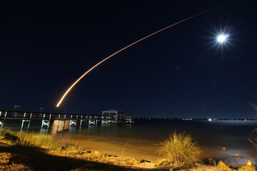 Rocket launch over a full moon