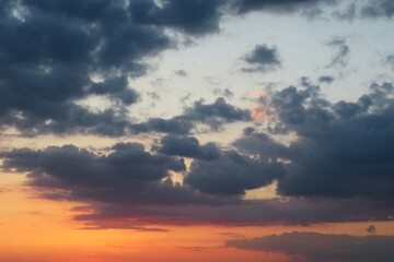Naklejka na ściany i meble Beautiful dark clouds at orange sunset