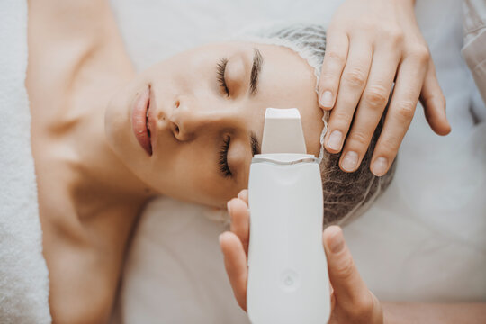 Top view of a caucasian woman getting skin analized by cosmetologist's hands, using skin analyzer.edical treatment. Facial treatment. Cosmetology beauty