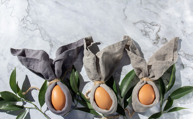 Festive easter background with Easter bunny eggs on linen napkin. Easter decoration, top view. Copy space