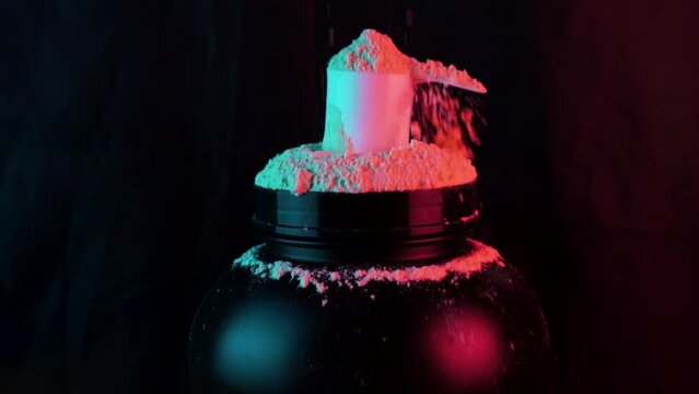 Protein powder falling into spoon on black background