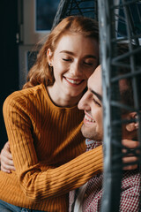Close-up view of a couple at home sitting on sofa enjoying spending weekend together. Smiling caucasian faces.