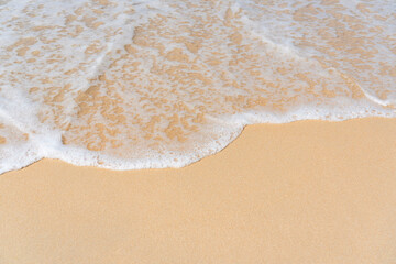 Top view of soft wave on sandy beach. Copy space