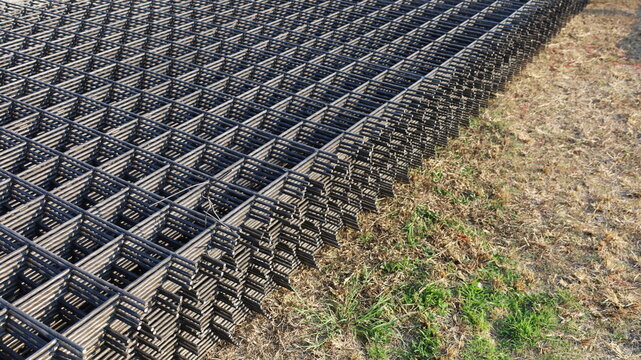 Wire mesh steel grid. BRC welded wire mesh piles on the ground for slab work in a construction site in natural light with copy space. Selective focus