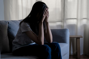 Mental health, depressed sad asian young woman, girl sitting on sofa, couch, expression to face difficulty, failure and exhausted. Thoughtful worried suffering depression feeling lonely, alone at home