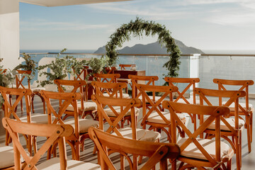 Decorative wedding chairs facing the altar. Ocean view in the background horizontal