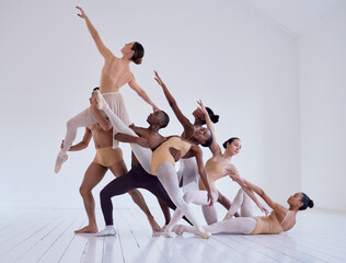 Pulling together to create beauty. Shot of a group of ballet dancers practicing a routine in a dance studio.