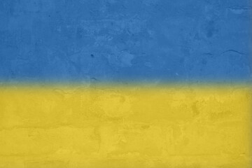 Ukrainian flag on a textured background. The flag of Ukraine on the old grunge wall in the background, the concept of destruction and war in Ukraine.Support for Ukrainians in the war with Russia