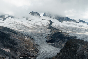 Blick auf einen Gletscher und Berge in den Wolken