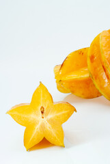 白背景の南国果物のカットされたスターフルーツと2個のカットされてないスターフルーツ