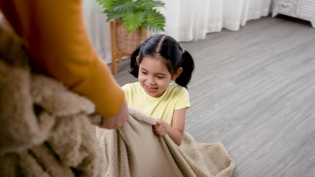 4K 25fps Slow Motion, adorable Asian girl with two hair tied up, playing with her sister dragging the blanket in the living room of her house, having fun.Family and Healthy.