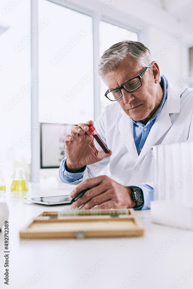 Poster Its easier to log detailed observations with technology. Shot of a mature scientist analyzing a test tube while using a digital tablet in a lab.