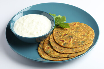 Thepla Indian flat bread,Methi Paratha,an Indian flatbread stuffed with fenugreek leaves and spices served with yogurt in breakfast or brunch .