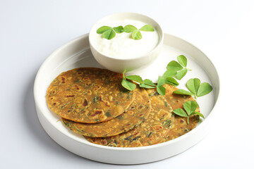 Thepla Indian flat bread,Methi Paratha,an Indian flatbread stuffed with fenugreek leaves and spices served with yogurt in breakfast or brunch .
