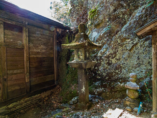 日龍峯寺崖ぎわの本堂裏の石灯籠と石塔