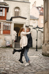 Fototapeta na wymiar Romantic couple hugging and kissing in the street of old town