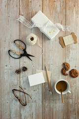 Cozy home table with greeting card, wrapped gift and hot chocolate