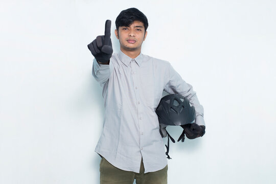 handsome asian man with a motorcycle helmet open hand doing stop sign with serious expression defense gesture isolated on white background

