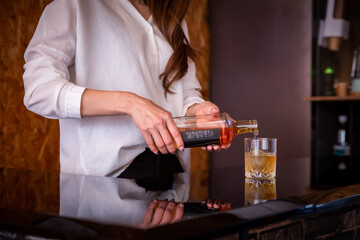 バーカウンターでお酒を提供する女性　BAR
