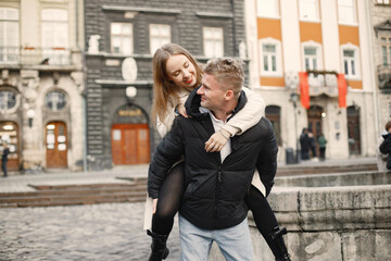 Fototapeta premium Romantic couple hugging while walking in the street of old town
