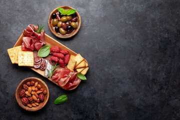 Antipasto board with prosciutto, salami, crackers, cheese, olives