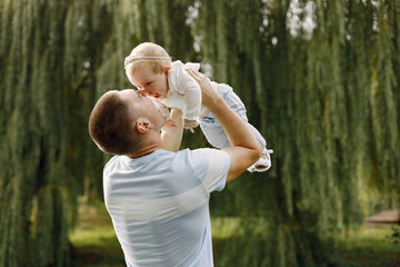 Young father throwing his little daughter up in the air
