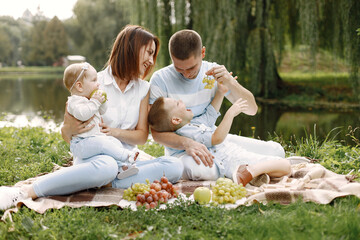 Fototapeta premium Happy family have a picnic in park near the lake