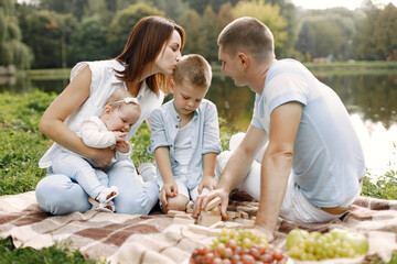 Happy family have a picnic in park near the lake