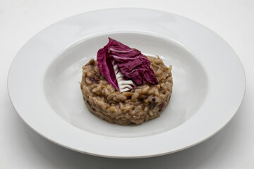 Risotto with red radicchio in a white dish. Italian cuisine.