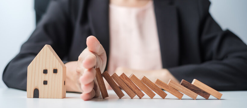 Businessman stop falling wooden blocks and protect house model. Crisis, fall Business, Risk, Economic recession, Developer, Real Estate and Property concept